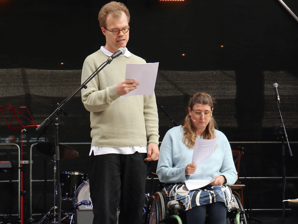 Die Botschafter*innen der Interessenvertretung von Leben mit Behinderung Hamburg, Fabian Pietzcker und Annika Albers, halten eine Rede